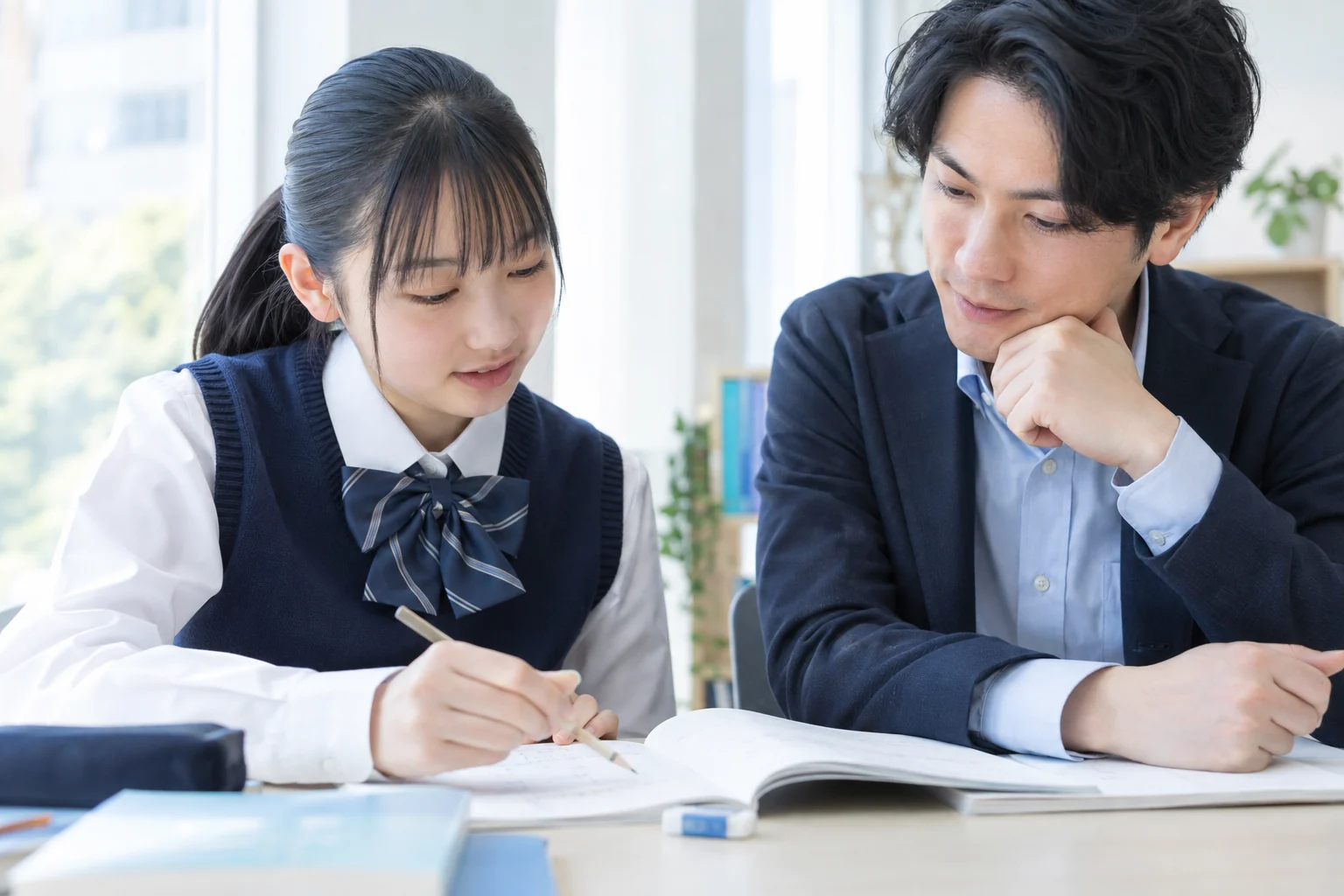 答案の考え方を説明する生徒と、耳を傾ける講師